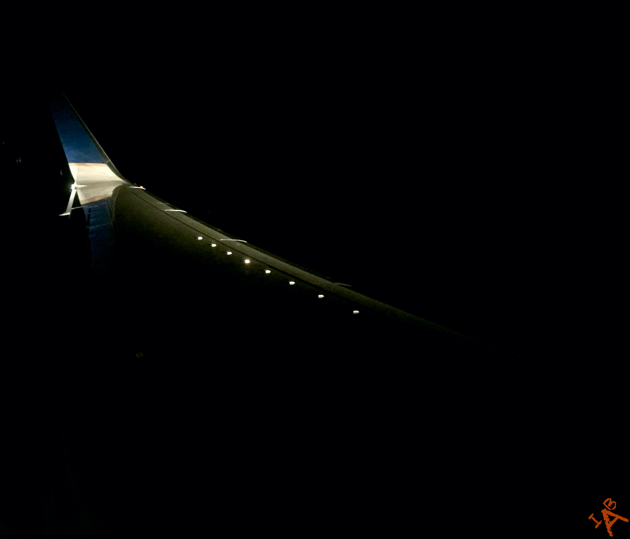 An airplane wing lit up at night.