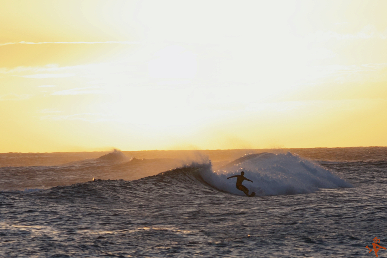 A surfer at sunset in Hawaii.